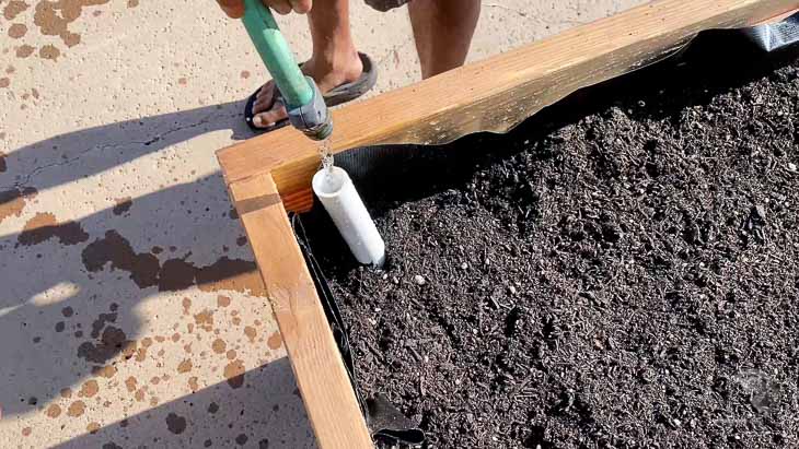filling water in the self-watering garden bed