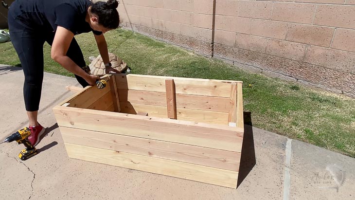 woman building a planter box in backyard