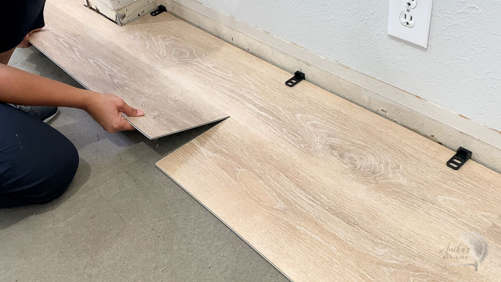 woman installing second plank of the vinyl plank flooring