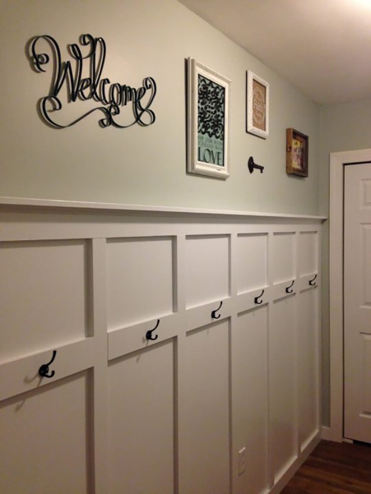 white Entry way board and batten wall with black hooks