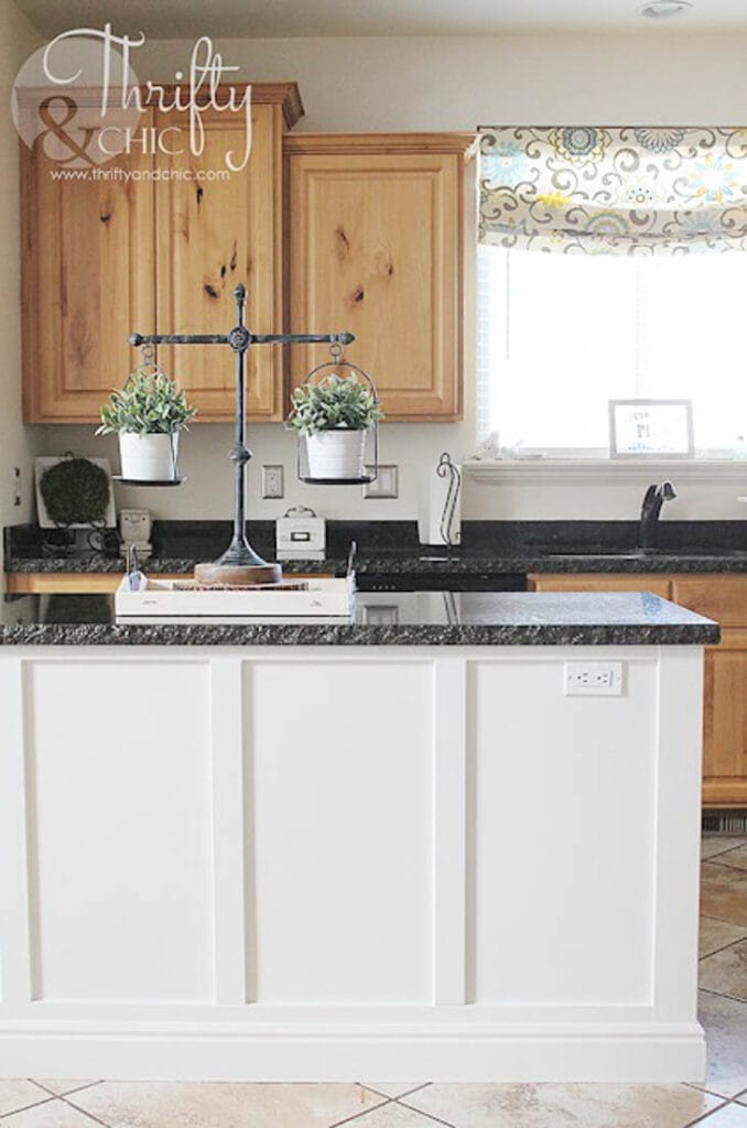 kitchen island with board and batten trim painted white with black stone countertop