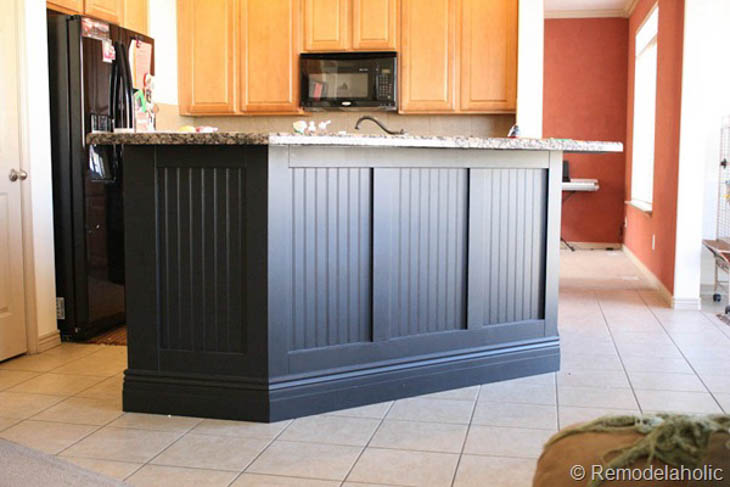 black kitchen island with beadboard framed with wood trim
