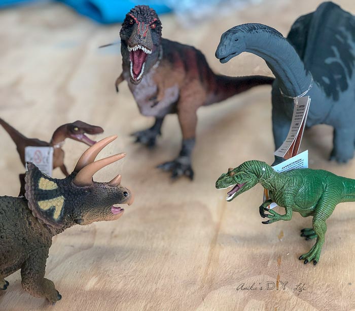 Plastic dinosaurs on wooden bench