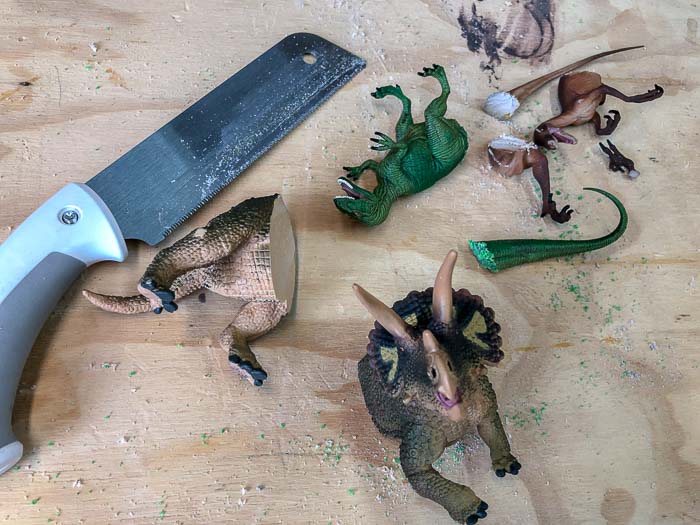 Dinosaur with their backs cut off using a hand saw for the DIY Dinosaur shelf