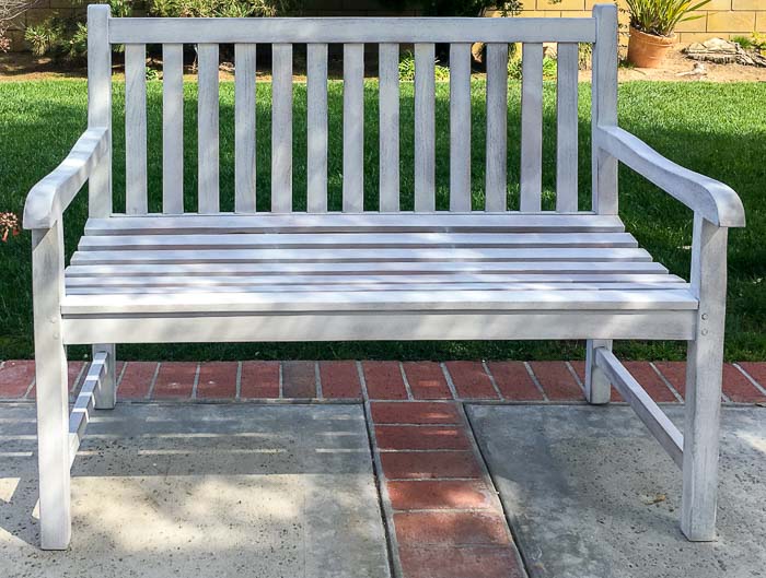 Outdoor bench with one coat of primer in backyard