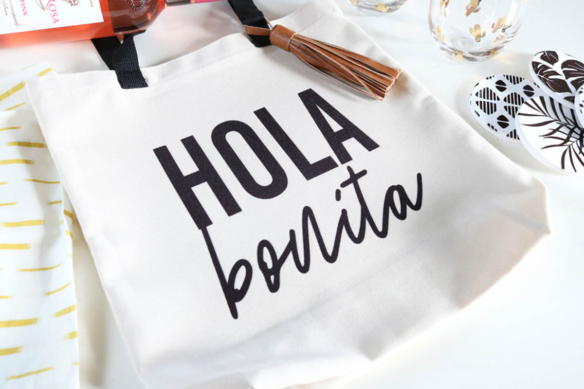 Tote bag with HOLA Bonita printed on it using a Cricut machine.