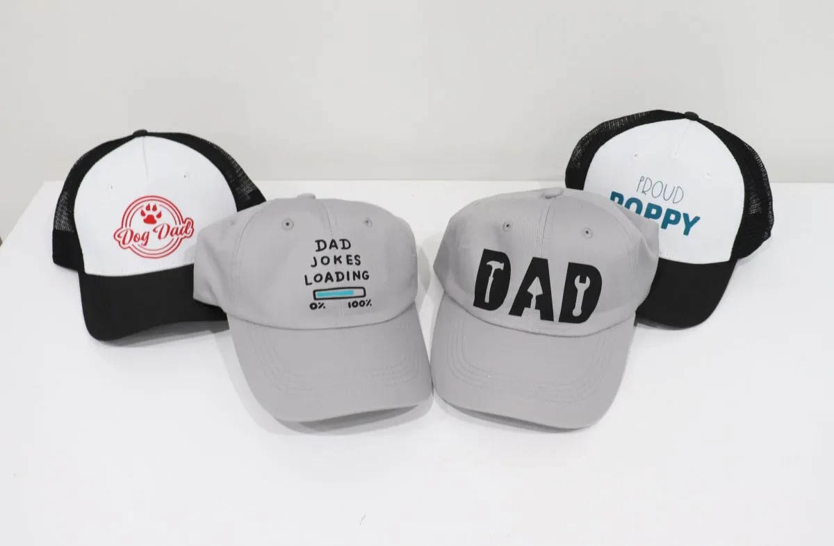 Four ball caps personalized for Dad using a Cricut