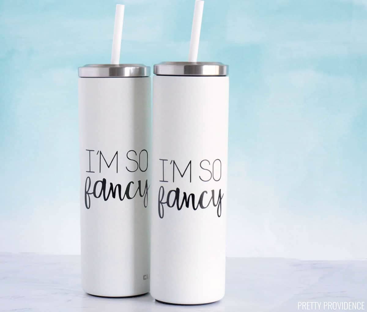White tumblers with straws and custom decals made with Cricut