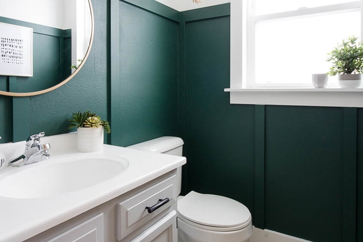 Dark green board and batten wall in a white bathroom
