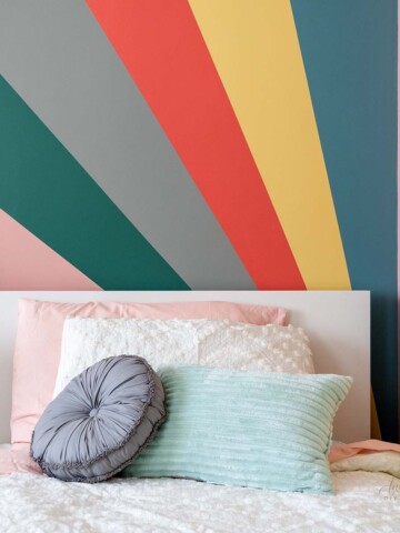 Learn how to paint a DIY Sunburst rainbow accent wall with this step-by-step tutorial. We added a little surprise by painting it in a corner!
