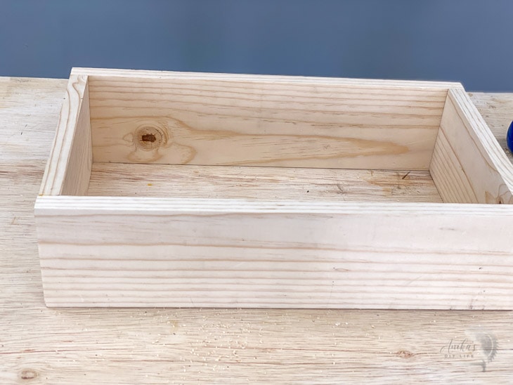 rectangular box with no top or bottom on a workbench