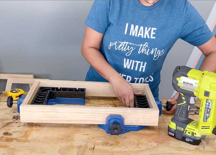 woman building a small square box using clamps